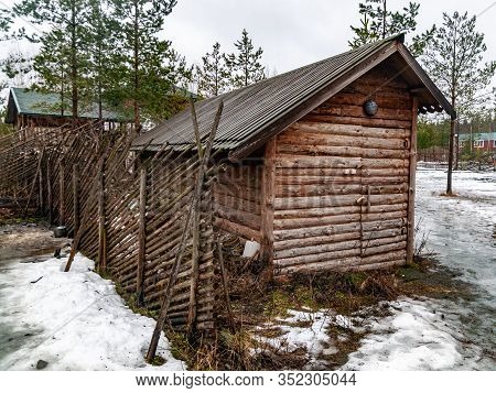 Winter Landscape With A Wooden Shed And A Fence Of Poles