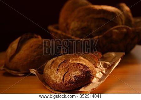 Different Buns Of Fresh Bread On A Brown Vintage Background. Freshly Baked Wheat Bread, Still Life W