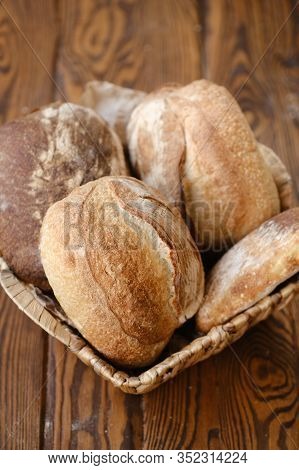 Different Buns Of Fresh Bread On A Brown Vintage Background. Freshly Baked Wheat Bread, Still Life W