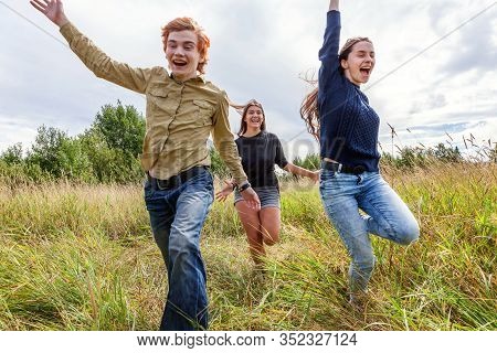 Summer Holidays Vacation Happy People Concept. Group Of Three Friends Boy And Two Girls Running And 