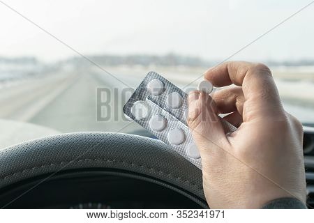 View Of The Driver Hand Holding A Bag Of Pills While Driving On The Highway