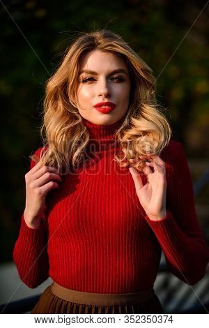 Girl Long Blond Hair. Girl Red Lipstick In Knitwear Sweater. Cosmetics And Skin Care Trend. Autumn W