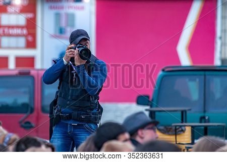 Lutsk, Ukraine - 05-24-2015: Photographer With A Long Lens Nikon Camera Captures Crowd Scenes At The