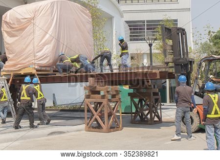 Train Head, Covering The Pink Cloth Moving By Worker Pushing From Orange Forklift Is Lifting, Wearin