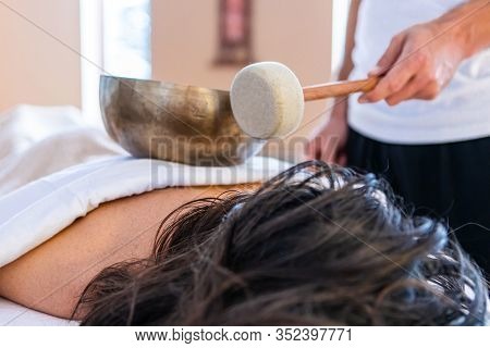 Sound Therapy And Sound Massage For Body And Mind. Man Holding A Bronze Bowl With A Stick - Used For