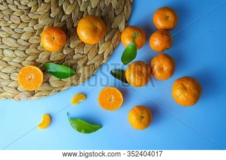 Top View Of Ripe Fresh Mandarines Or Tangerina Orangers With Green Leaves In Blue Background With Pl