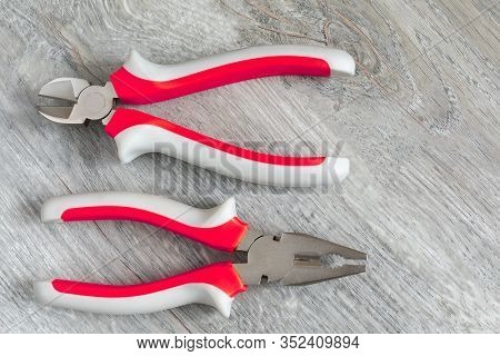 A Set Of Two Different Types Of Pliers And Side Knives On A Gray Laminate. Image On The Theme Of Rep