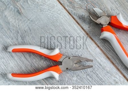 A Set Of Two Different Types Of Pliers And Side Knives On A Gray Laminate. Image On The Theme Of Rep