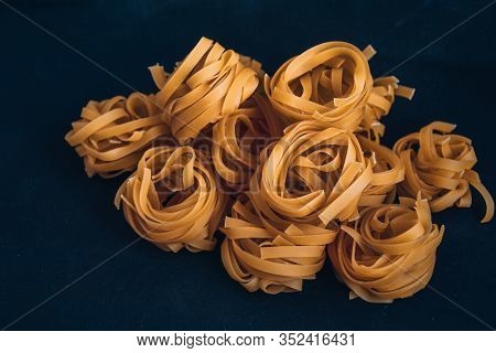 Pasta Alluovo, Tagliatelle Pasta, Round Balls Of Raw Pasta On Black Background, Close Up Of A Raw Dr