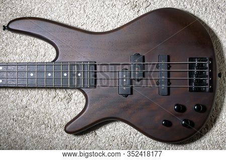 Left-handed Bass Guitar With Four Strings. Popular Rock Musical Instrument. Top View Of Brown Electr