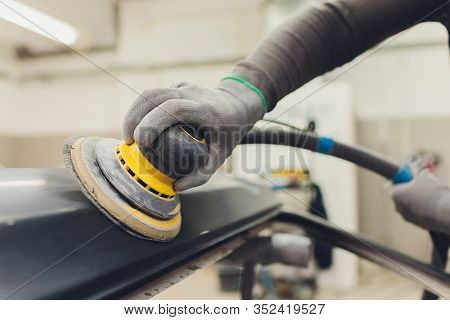 Auto Mechanic Preparing The Car For Paint Job By Applying Polish With The Power Buffer Machine