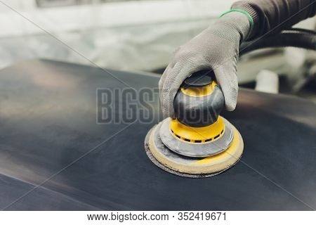 Auto Mechanic Preparing The Car For Paint Job By Applying Polish With The Power Buffer Machine
