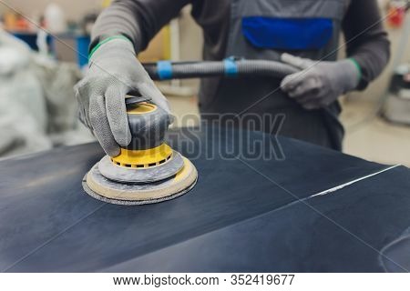 Auto Mechanic Preparing The Car For Paint Job By Applying Polish With The Power Buffer Machine