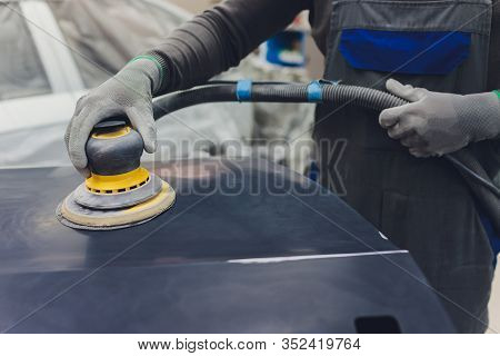Auto Mechanic Preparing The Car For Paint Job By Applying Polish With The Power Buffer Machine