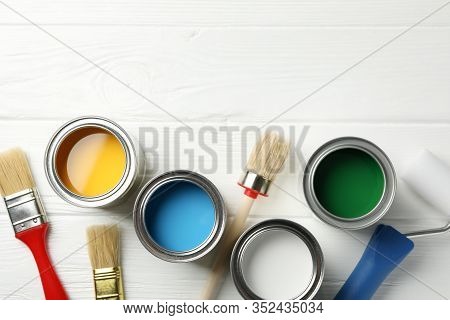 Different Paints, Brushes And Roller On Wooden Background, Top View