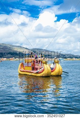 Uros, Peru - Jan 5, 2019. Traditional Totora boat with tourists on Titicaca lake near to the Uros floating islands , Puno, Peru, South America.