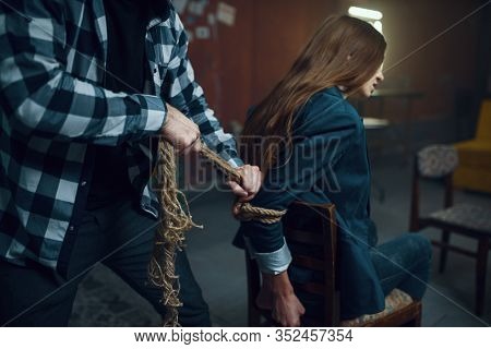 Maniac kidnapper ties his female victim with rope