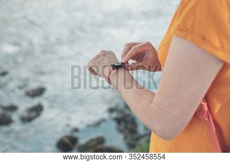 Woman Hiker Using Smart Bracelet During Trekking In Nature. Close Up Of Female Hands With Portable I