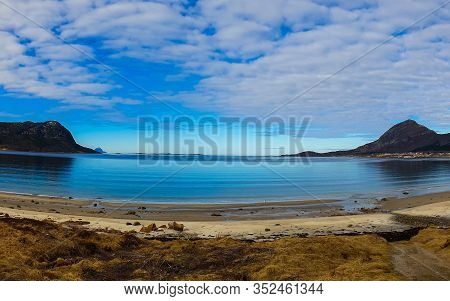 Beach In A Blue Lagune With Some Mountains And A Horizont In Northern Norway