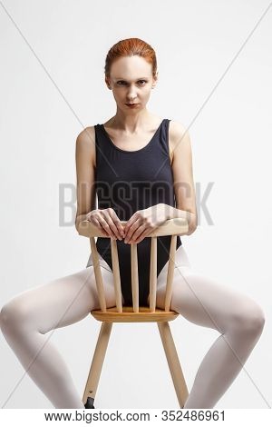 Portrait Of Serious Caucasian Ballet Dancer In Body Suit And Pointes Shoes Sitting On High Chair Aga