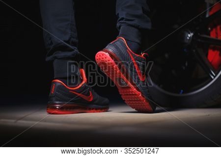 A Man Wearing Perfect Nike Air Max 2017 Sport Shoes Shot Near The Mercedez Benz Car On Dark Backgrou