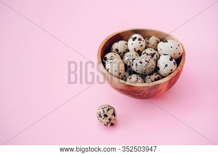 Quail Eggs In Wooden Bowl On A Pink Background. Easter Concept, Flay Lay Photo. Mockup, Space For Te