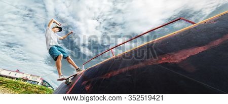 Portrait Of A Young Skateboarder Doing A Trick On His Skateboard On A Halfpipe Ramp In A Skate Park 