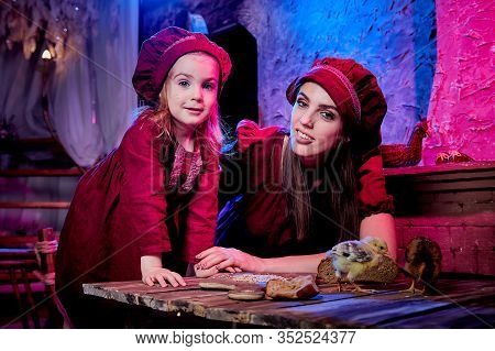 Easter And Family. Mother And Daughter In Maroon Or Red Dresses Of The Village Shepherdesses And Sma