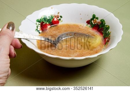 Raw Egg On A White Plate The Table, Small In It And A Spoon In A Womans Handon. Cooking Eggs For Coo