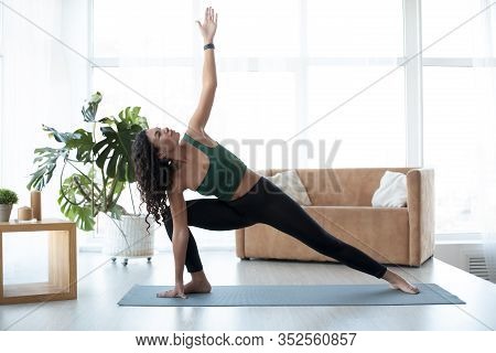 Wellbeing Concept. Young Hispanic Woman Doing Yoga At Home. Triangle Pose