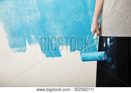 Girl In Workclothes Holds Roller In Her Hand, Empty Space