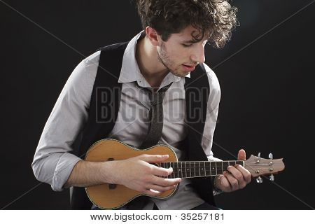 Nærbillede af unge mand spiller en Ukelele