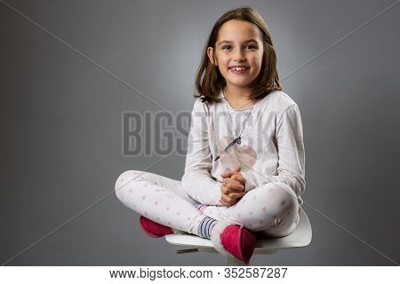 Portrait Of Happy Young Little Girl With Emotions On Gray.