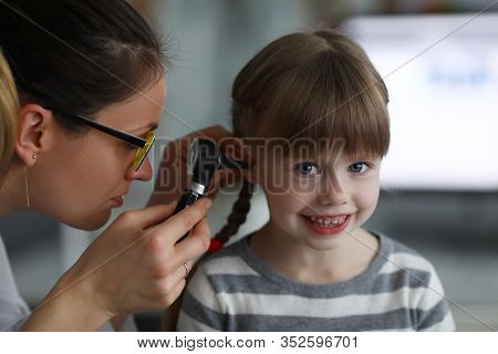 Close-up Of Smiling Little Patient Looking At Camera With Gladness. Ent Specialist Examining Unhealt
