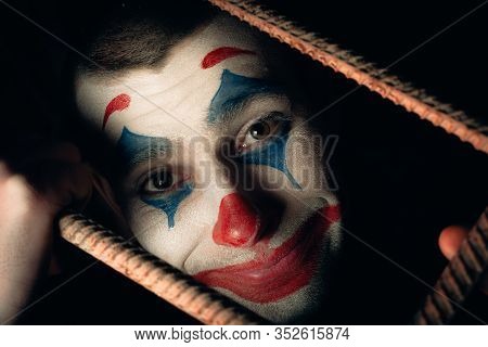 Close-up Portrait Of A Joker Man. Stock Photo Makeup Joker In A Horror Room.