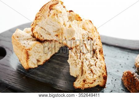 Burnt ciabatta with two kinds of butter. Aromatic fresh bread on wooden cutting board. Delicious rustic meal and cooking utensil. Traditional italian dish. Food presentation, pastry on white surface