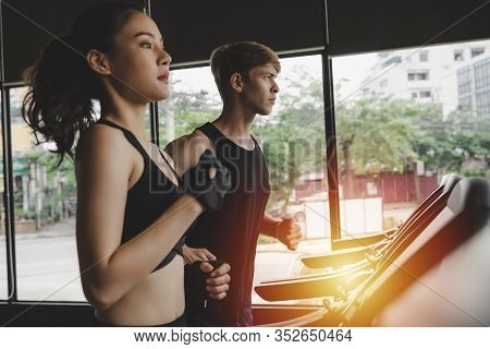 Running. Athletic Couple Young Sport People Slim Body Jogging Run Cardio Training On Treadmill Machi