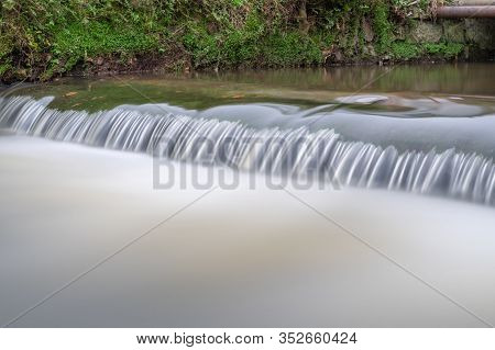 Long Exposure Of A Watefall On The River Lim Walkway At Lyme Regis In Dorset.