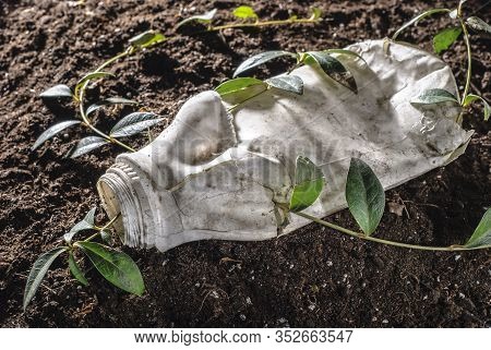The Problem Of Mankind Is Environmental Pollution With Plastic. An Angry Flower Fights Breaking Thro