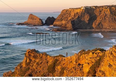 Woman On A Cliff At Praia De Odeceixe In Costa Vicentina, Portugal