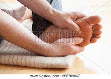 man doing flatfoot correction self massage at home
