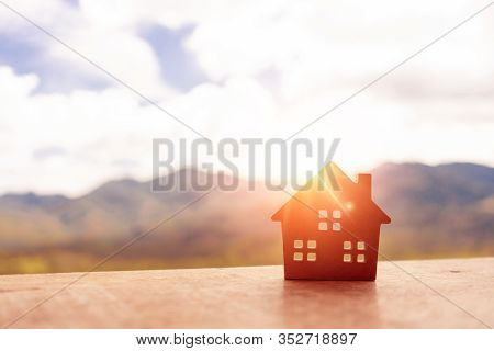 Closed Up Tiny Home Model On Floor Or Wood Board With Sunlight Green Bokeh Background. Deam Life Hav