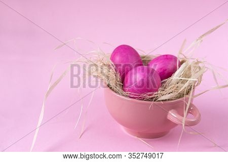 3 Pink Easter Eggs In A Pink Plate With Straw On A Pink Background