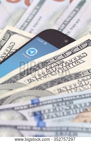 Smartphone Screen With Telegram App And Lot Of Hundred Dollar Bills. Business And Social Networking 