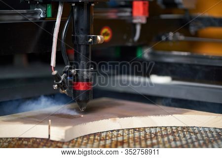 Computer cnc machine prent on wooden board in workshop