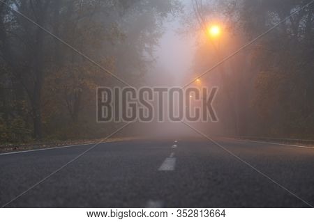Foggy Evening. Empty Road With Yellow Lights