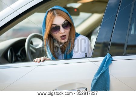 Young Fashionable Woman Driver Has Her Scarf Jammed In Vehicle Doors And Is Pulling It Out.