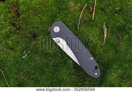 Pocket Knife On A Green Moss. Background From Natural Moss.