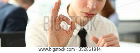Portrait Of Attractive Man Showing Ok Sign In Order To Let Good Colleagues Think Everything Under Co