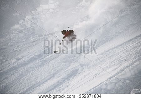 Skiier In Full Equipment Rides On A Ski In Mountains